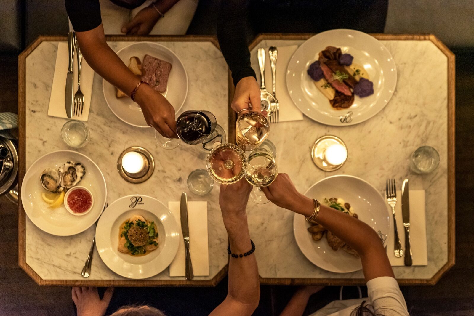 A beautifully set dinner table as friends raise their glasses