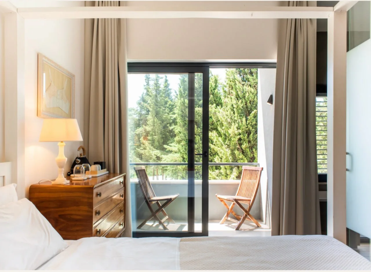 A serene room at DOMA with trees beyond the terrace