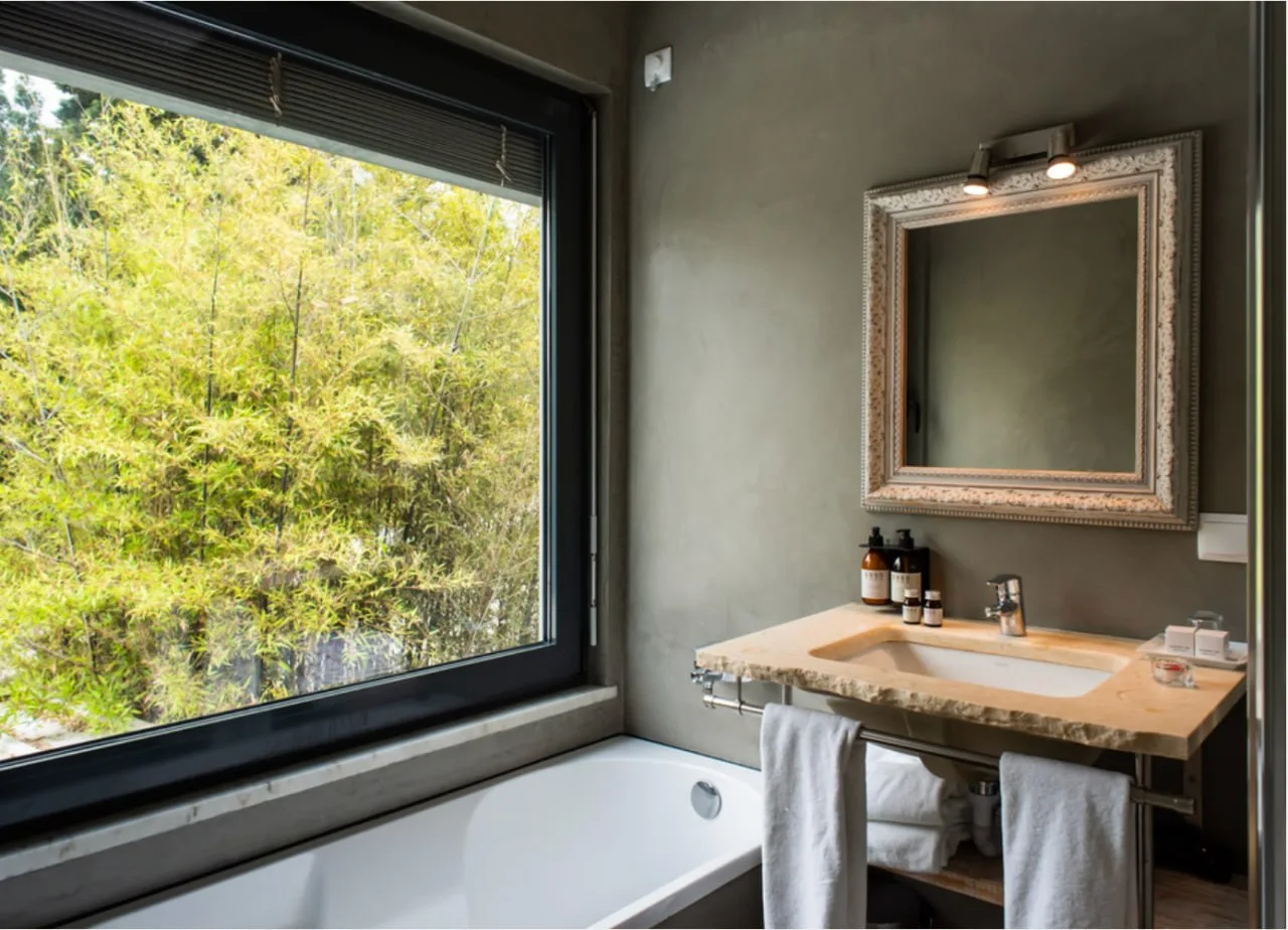 A private bathroom overlooking greenery at DOMA Portugal